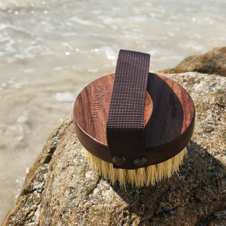 Cleaning brush with bristles on a rock by a beach